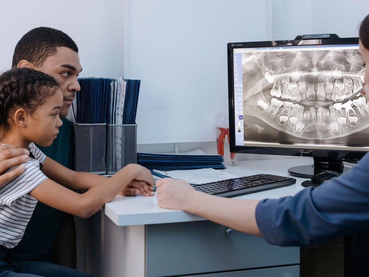 A child and parent looking at an x-ray on screen