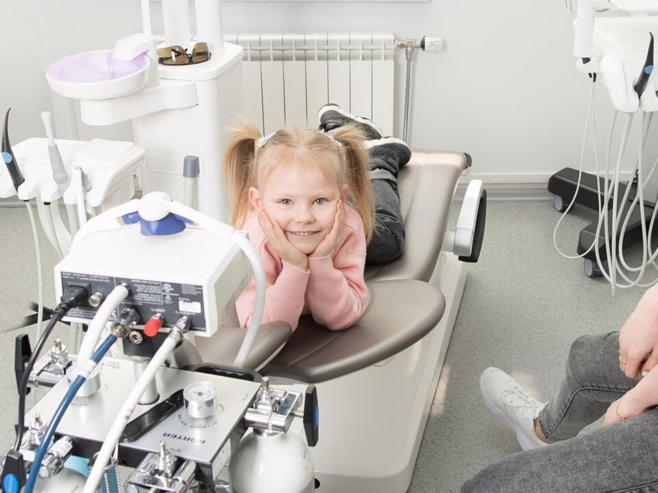 A child in the dental chair with a parent nearby