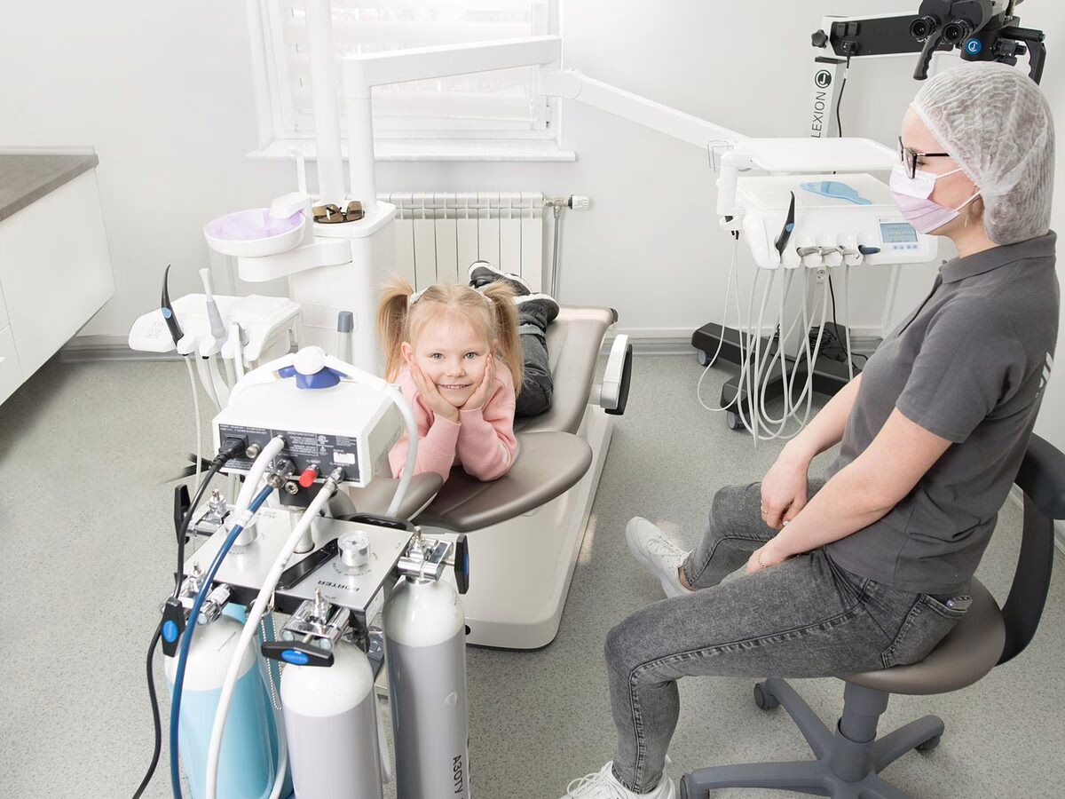 A child in the dental chair with a parent nearby
