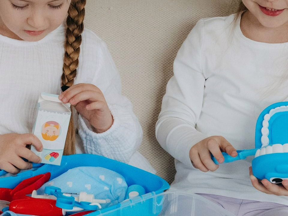 Children playing with a toy dentist kit