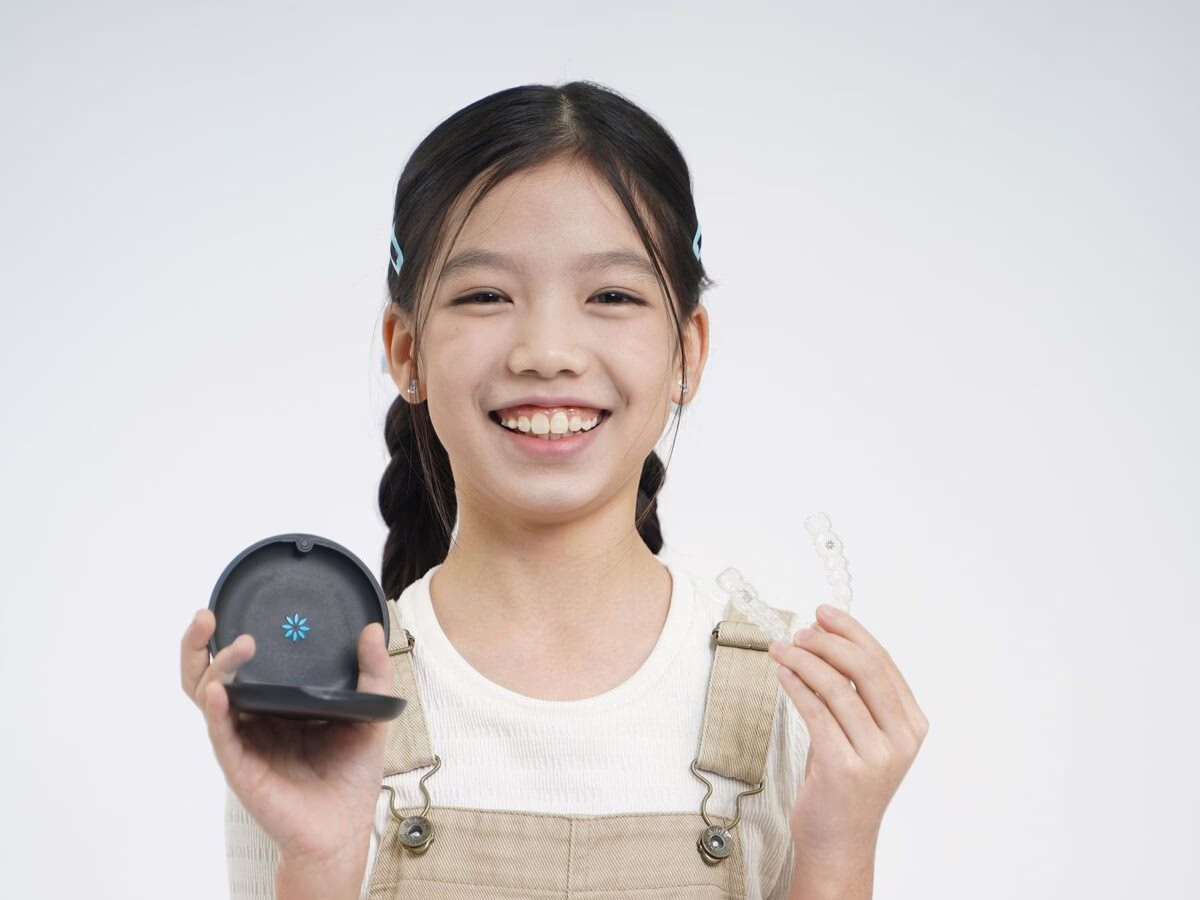 A girl holding a clear aligner and its case
