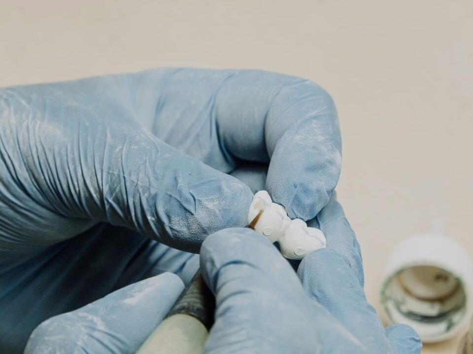 A dental technician fitting an implant component