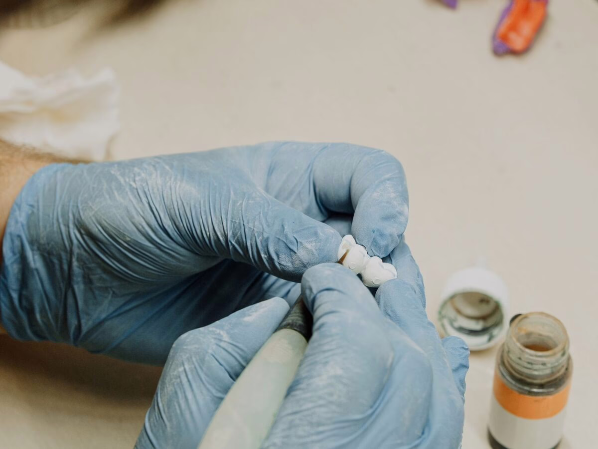 A dental technician fitting an implant component