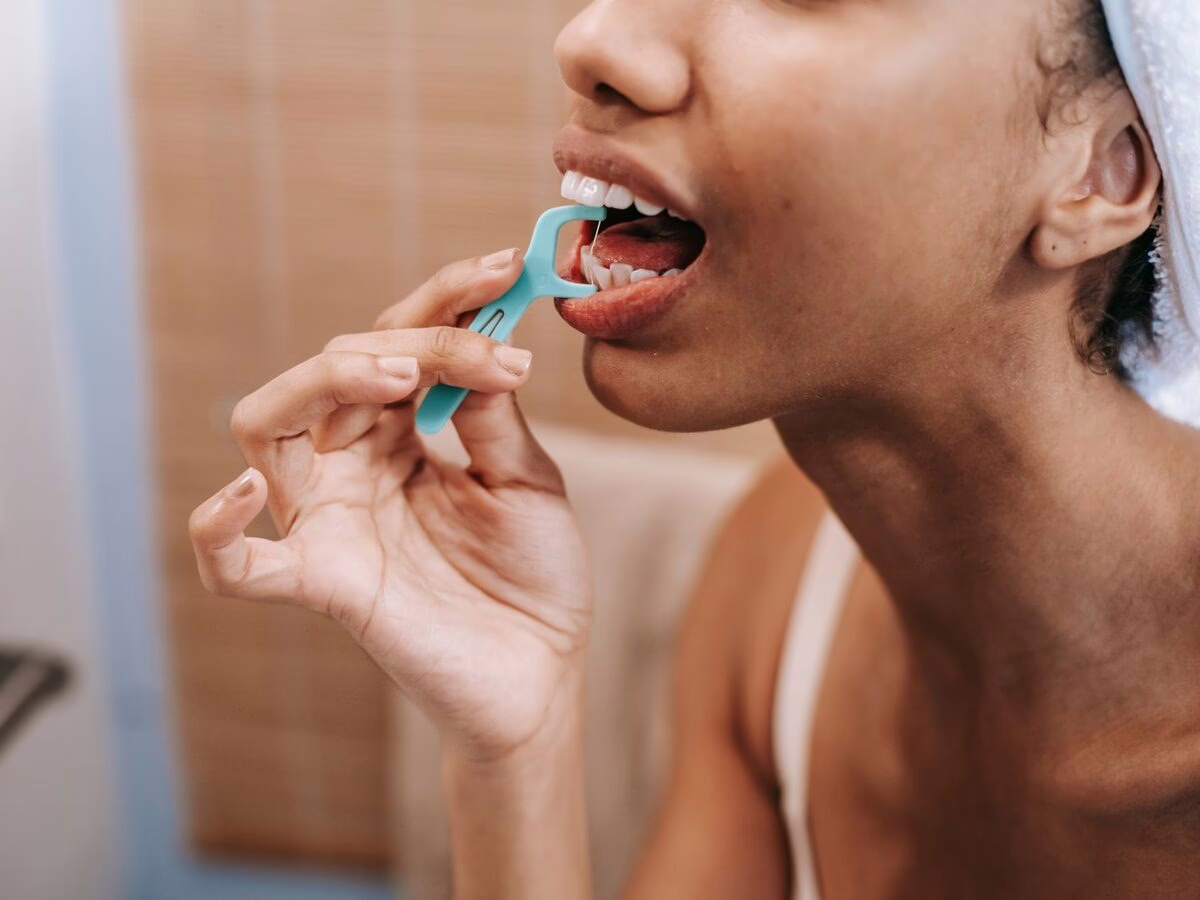 A woman flossing her teeth