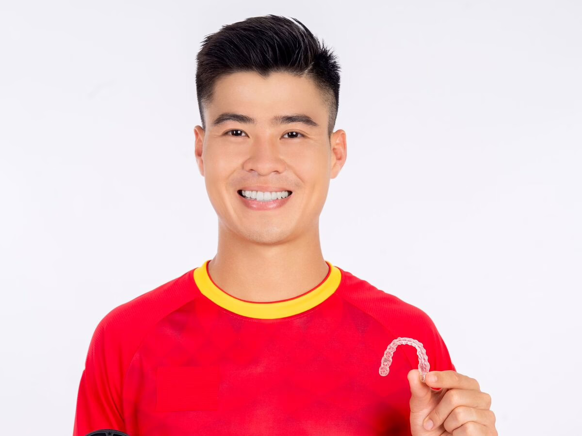 A young man holding a clear aligner and case