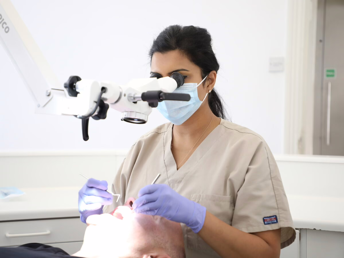 Dr Neha Patel treating a patient under the microscope