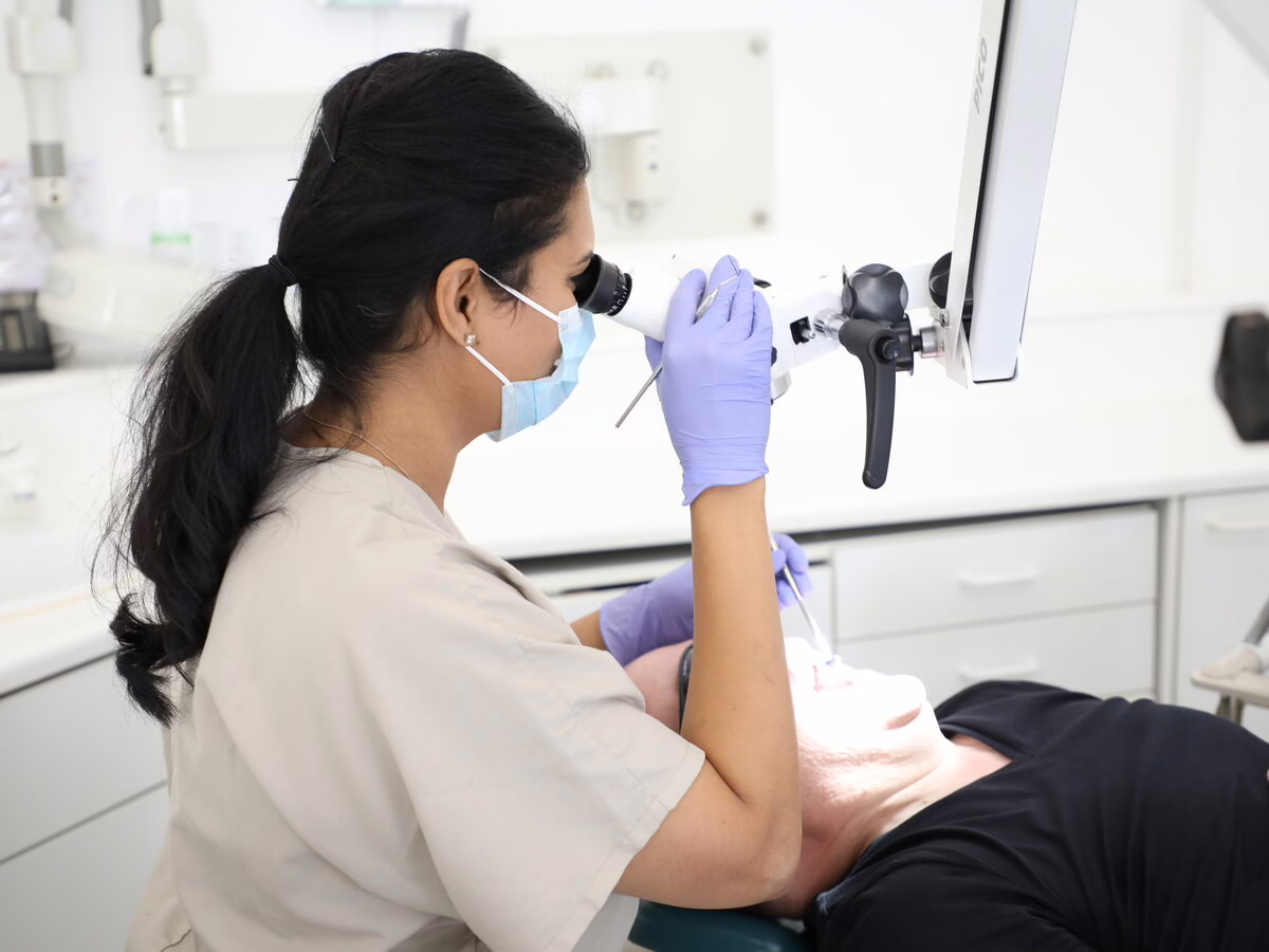 Dr Neha Patel treating a patient under the microscope