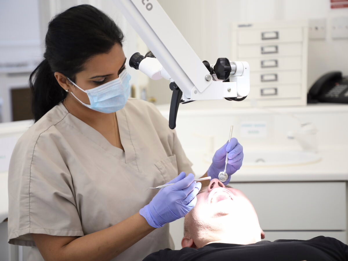 Dr Neha Patel treating a patient under the microscope