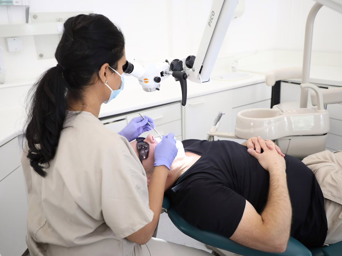 Dr Neha Patel treating a patient under the microscope