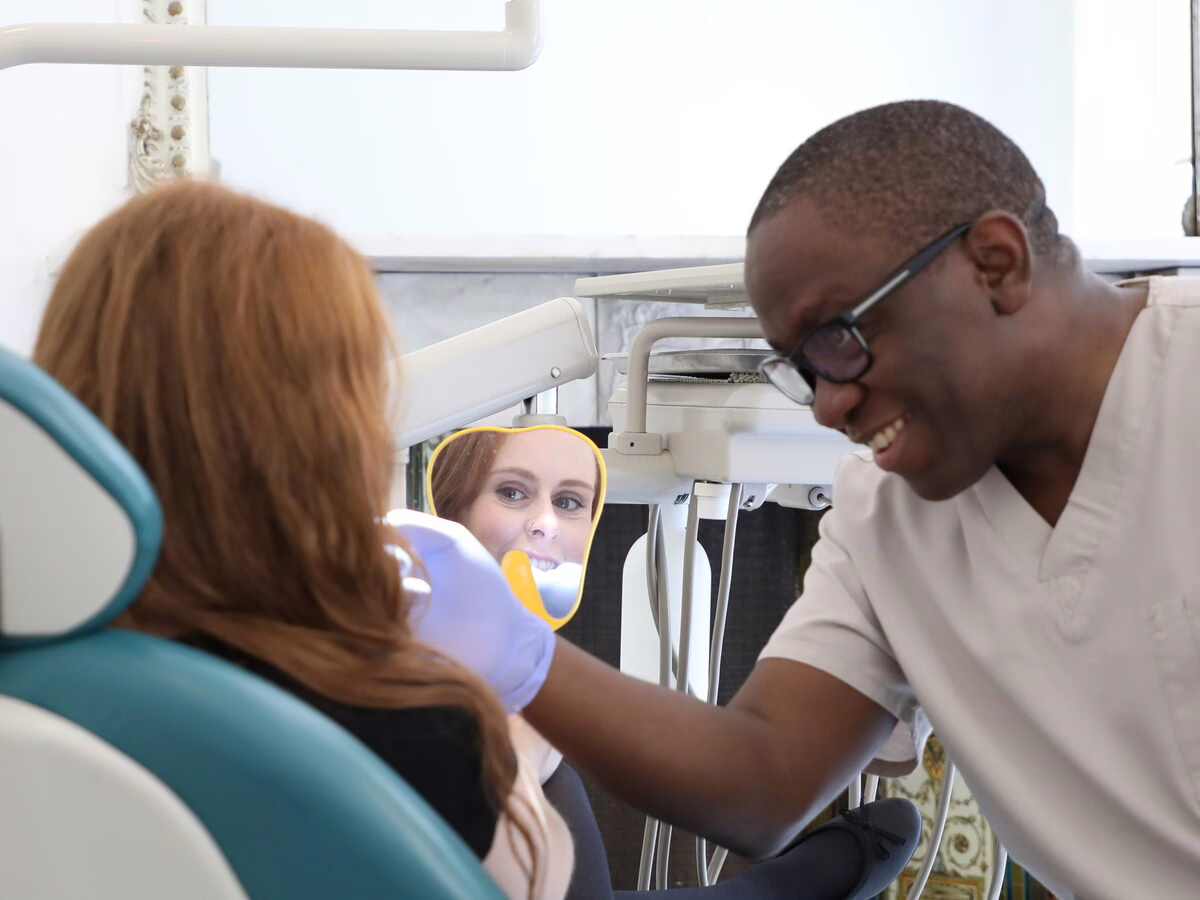 Dr Ope Sodeinde and the dental therapist with a patient