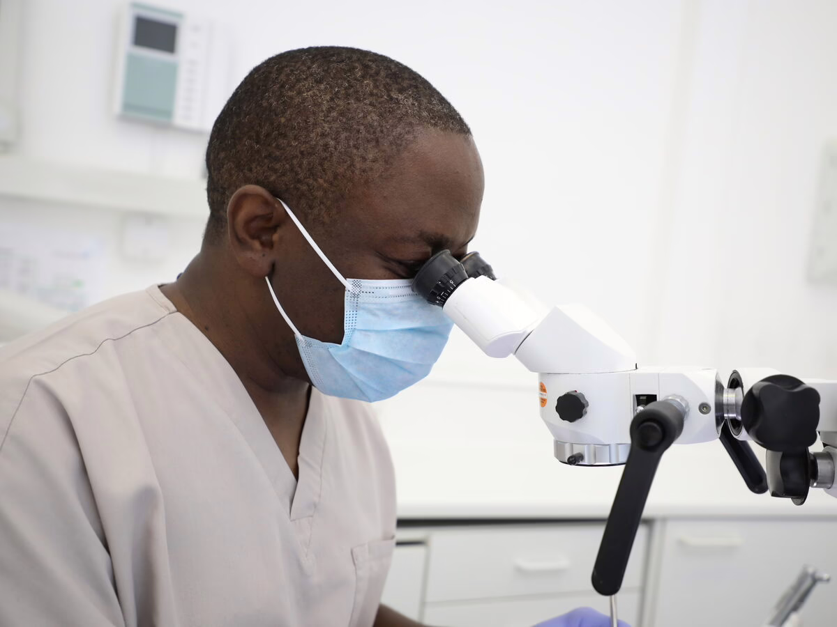 Dr Ope Sodeinde working at the operating microscope