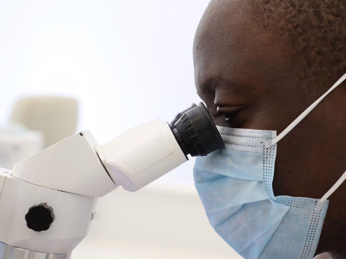 Dr Ope Sodeinde working at the operating microscope