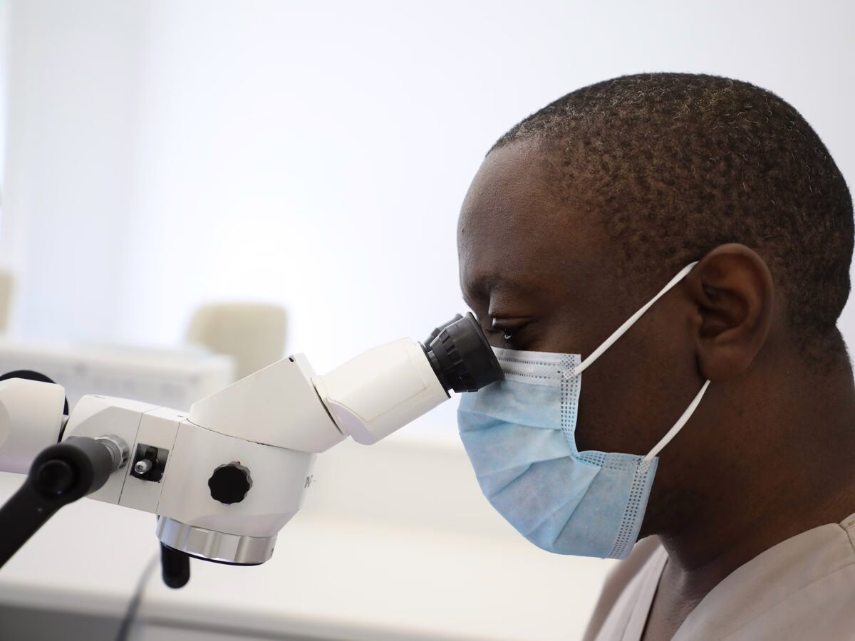 Dr Ope Sodeinde working at the operating microscope