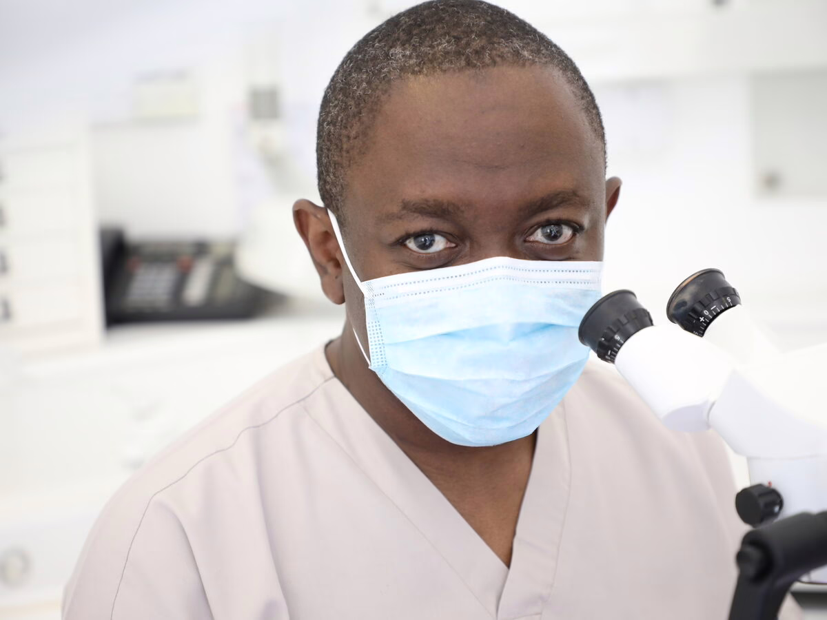 Dr Ope Sodeinde working at the operating microscope