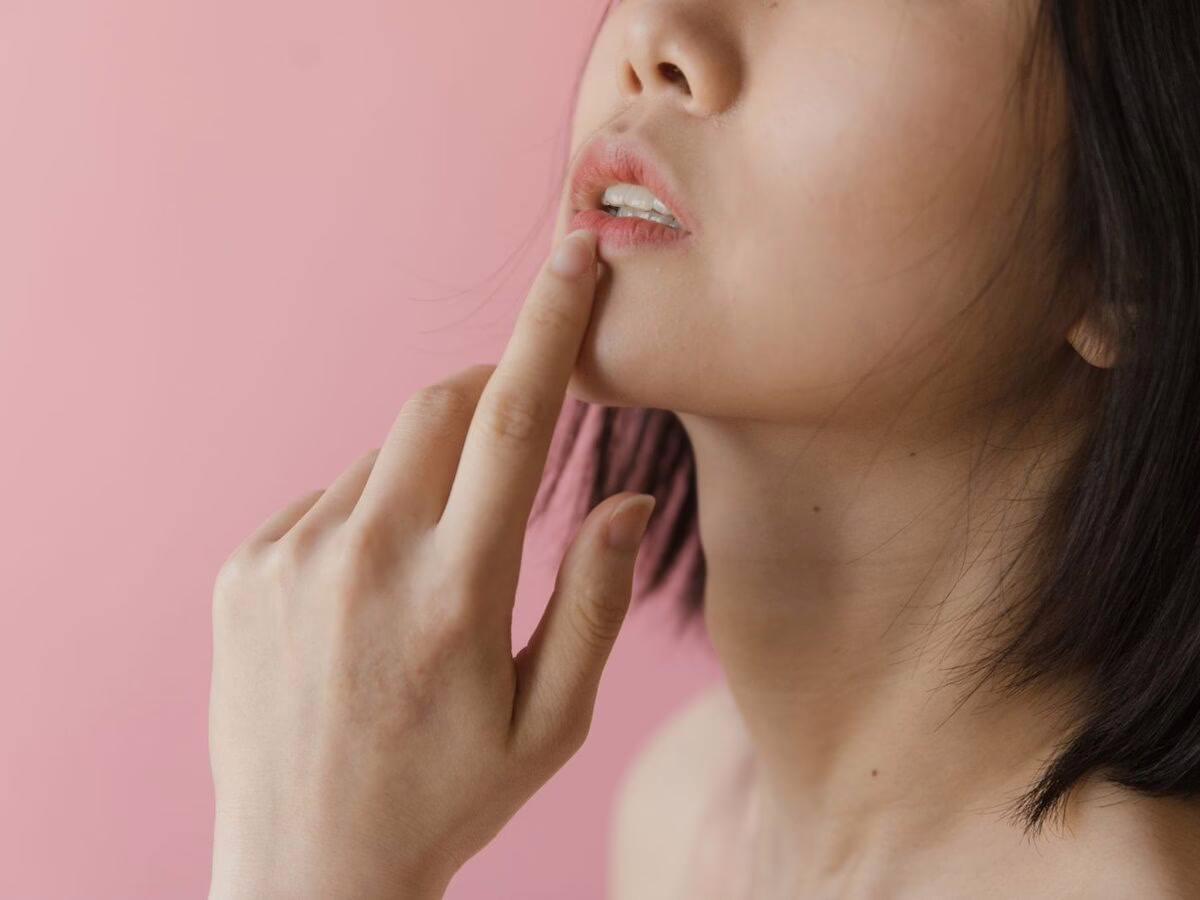 A finger resting on the lower lip